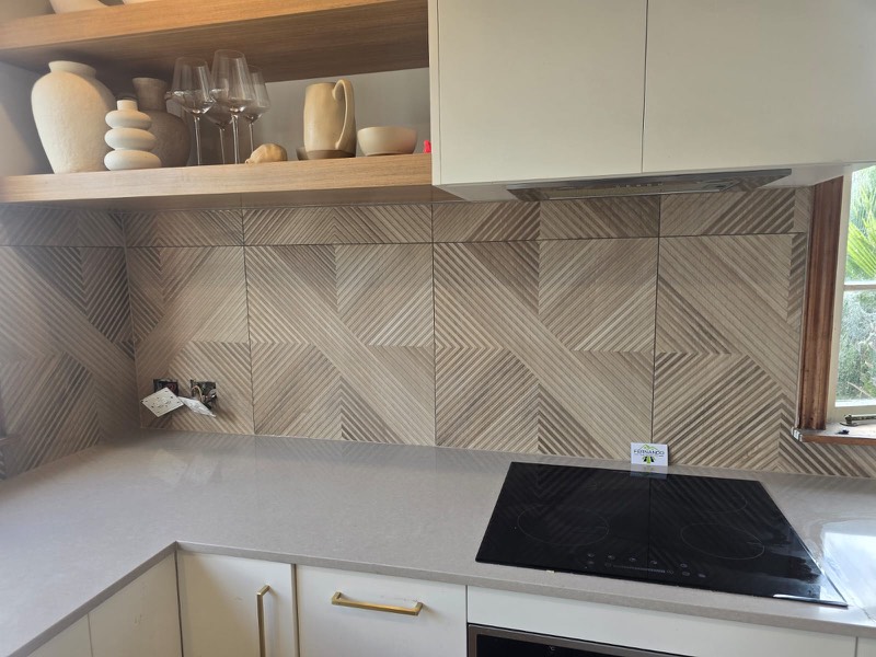 Geometric patterned designer splashback behind a kitchen cooktop